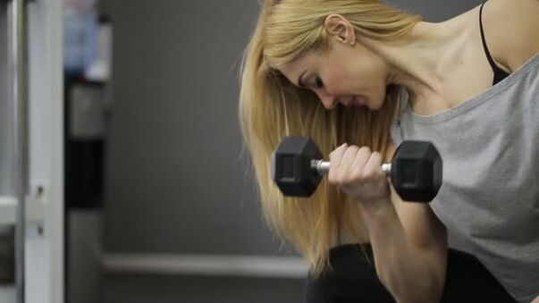 The girl exercises Dumbbell training